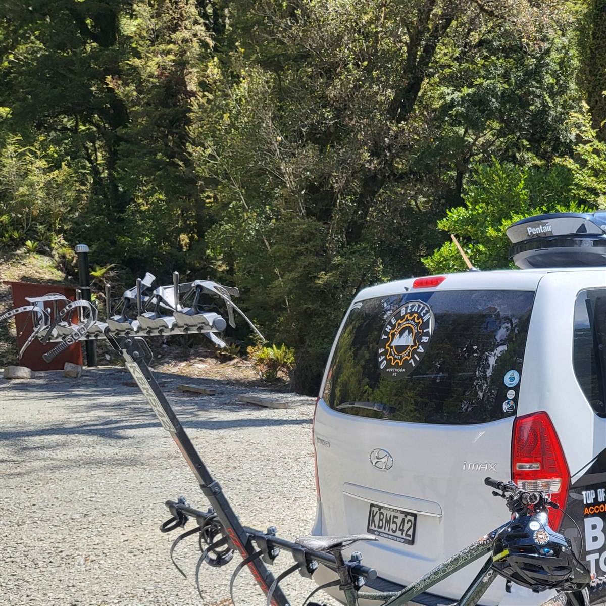 White Off the Beaten Trail shuttle van with a rear bike rack